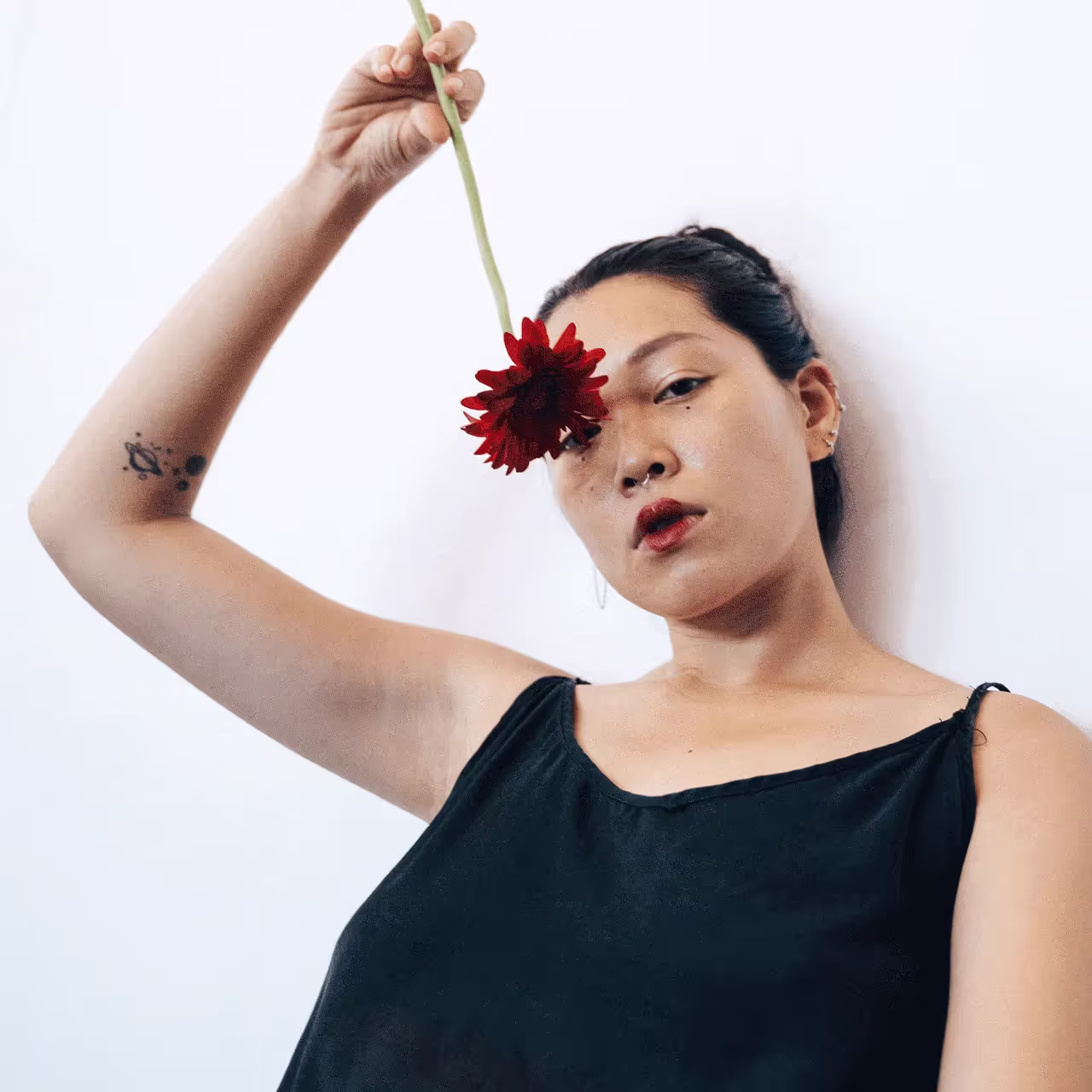 A woman holding a red flower above her head, symbolizing a urinary tract infection