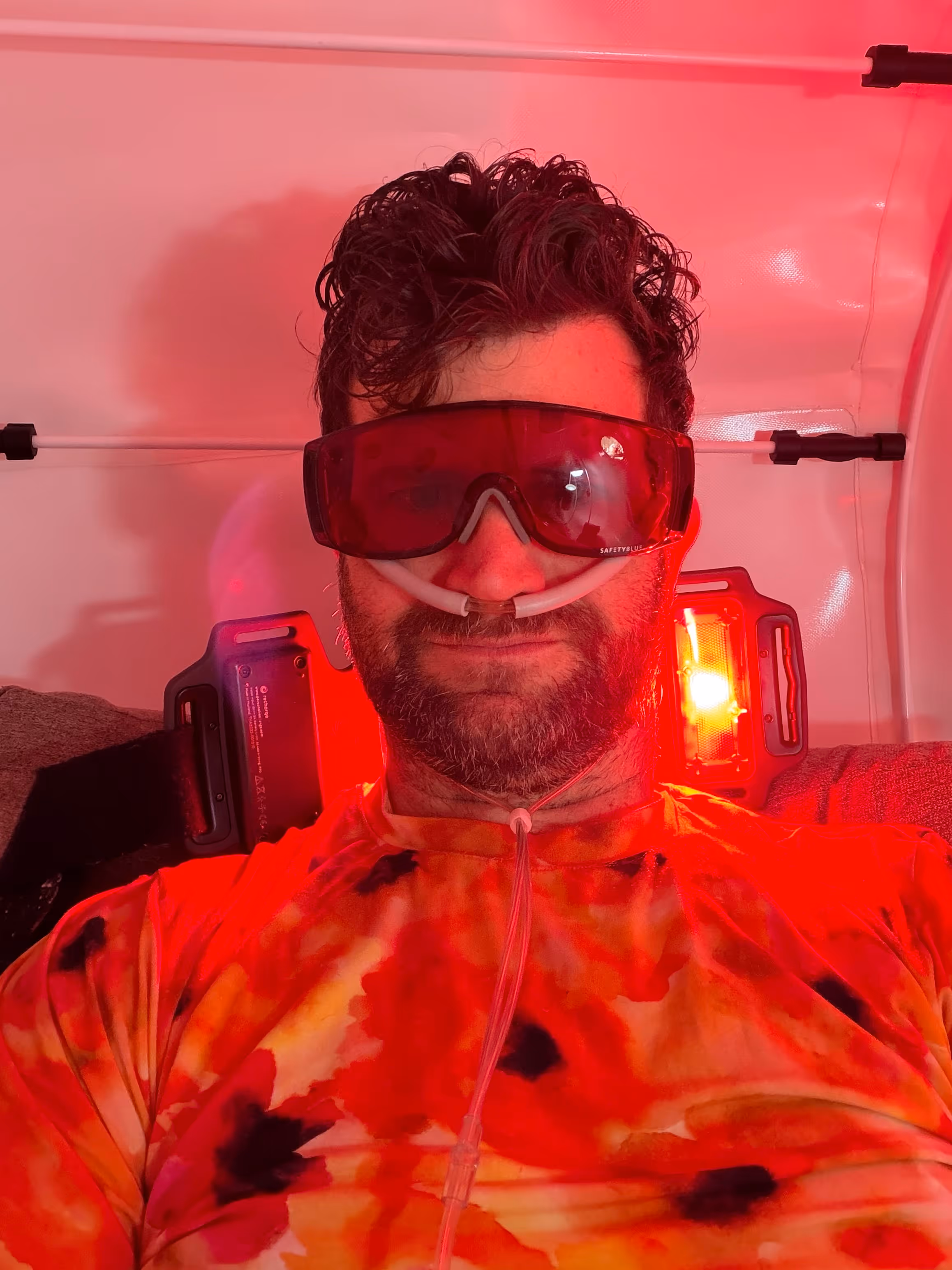 Joe, with googles, does regular sessions of hyperbaric oxygen therapy with red light therapy.