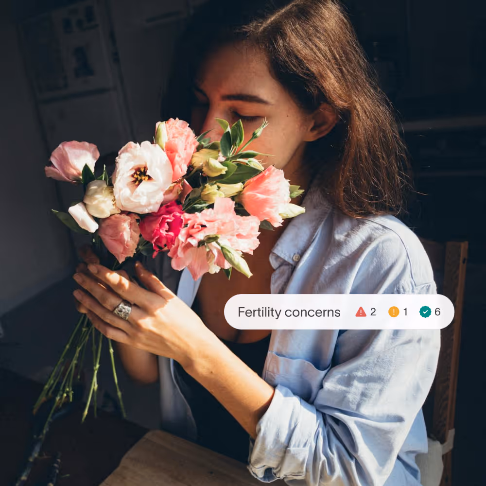 Woman smelling flowers with Tiny Health fertility concerns condition summary