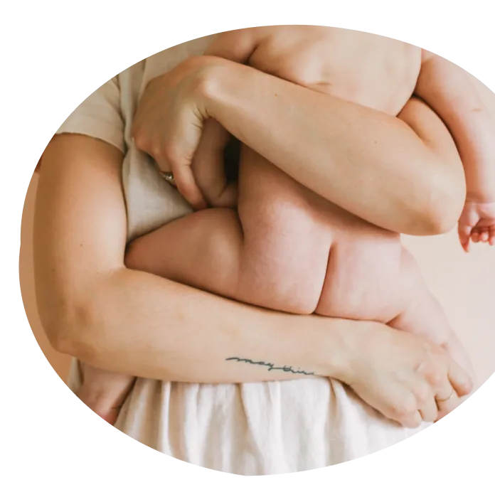 A woman is holding a baby in her arm