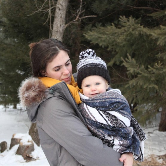 A happy mother of caucasian features in the forest with her baby in arms