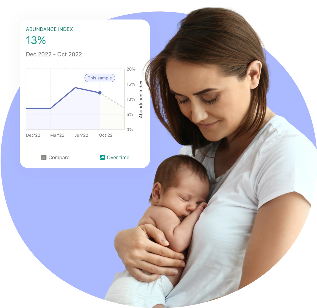 Mother in white shirt holding sleeping newborn baby against her chest.