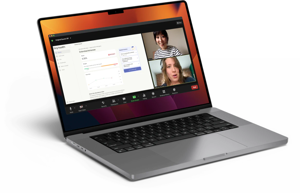 A laptop displays a video call with two women, alongside a health results screen showing metrics and graphs.