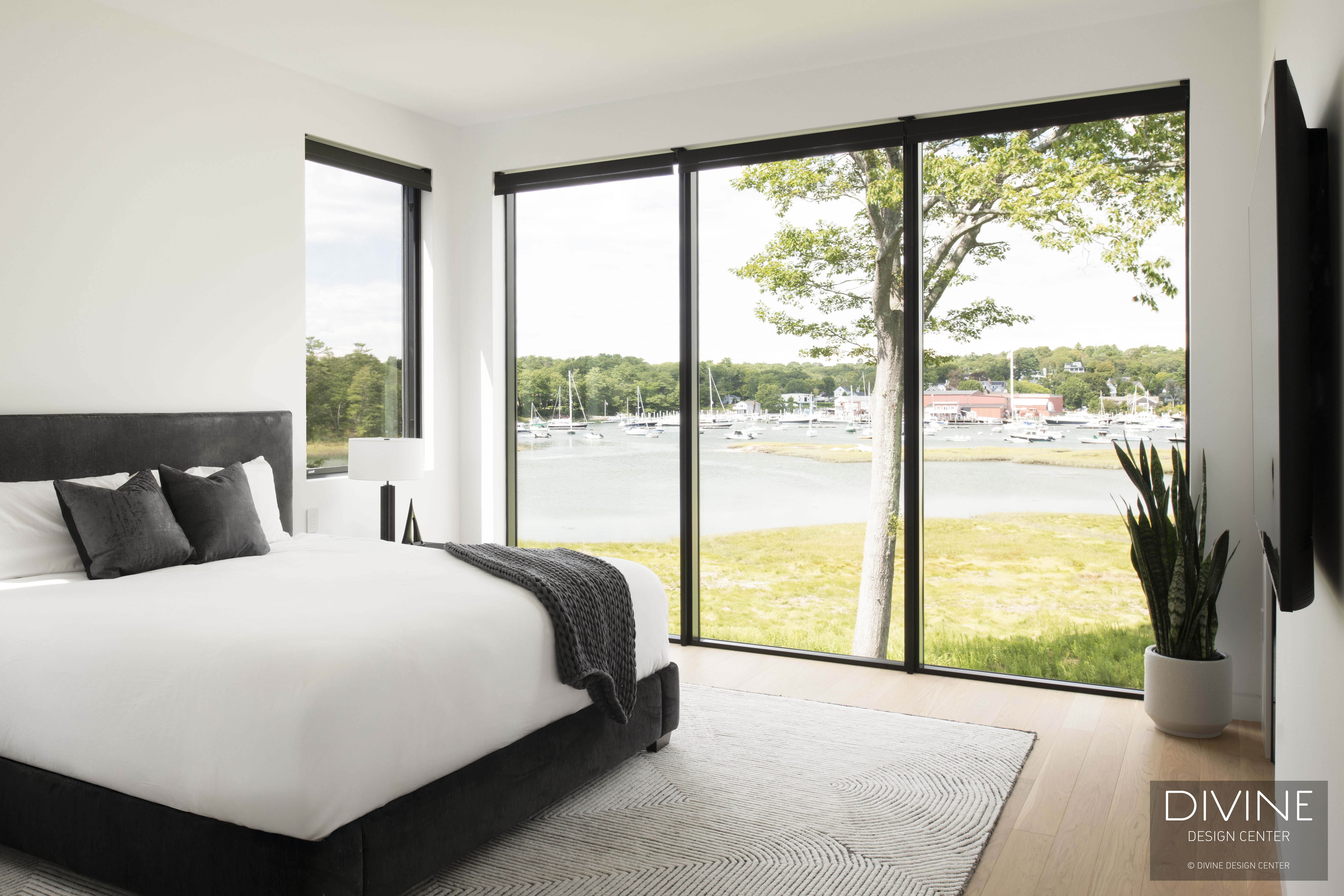 Master suite with modern bed frame, soft lighting, harbor views