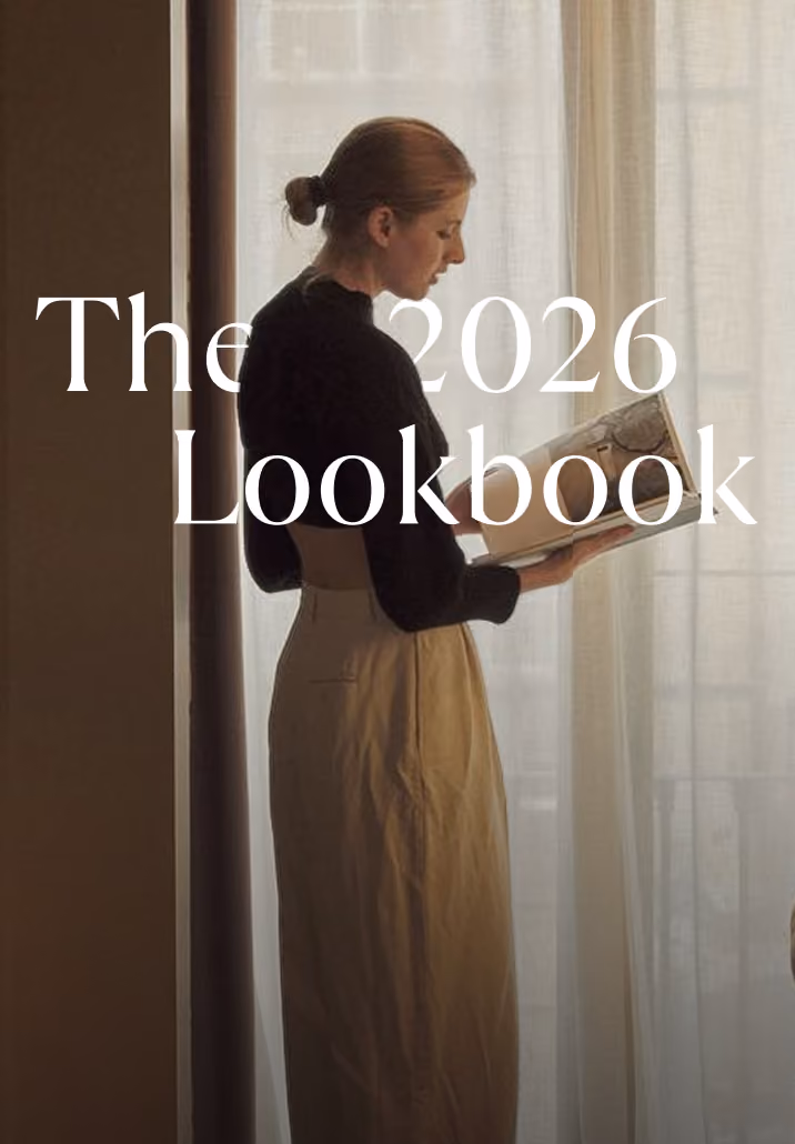 Side view of a woman reading a book near a bright window with sheer curtains.