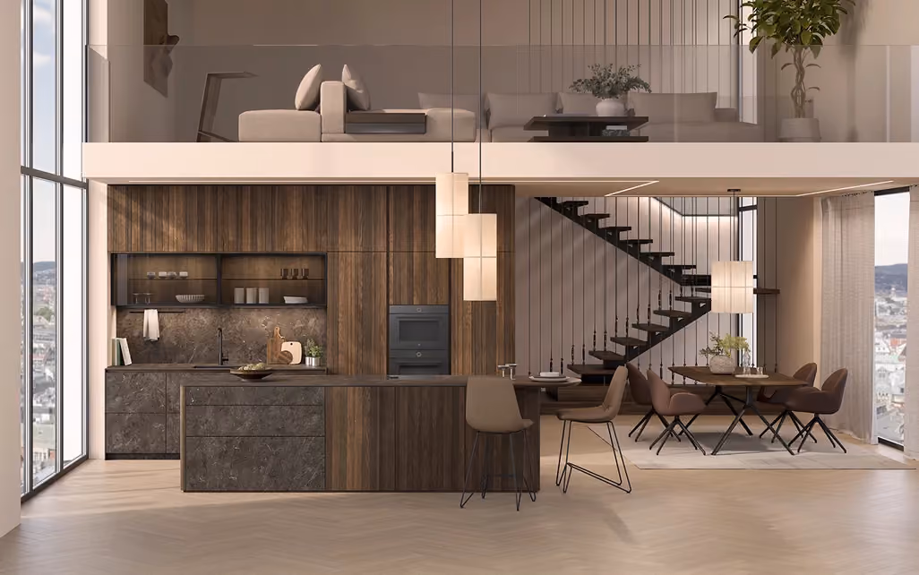 Modern open-plan living space with a double-height ceiling, featuring a walnut kitchen with an island and built-in oven, a dining area with six chairs, and a floating staircase with vertical cable railings leading to a mezzanine with a beige sofa and throw pillows, large windows offering a city view, and pendant lights hanging over the kitchen island.