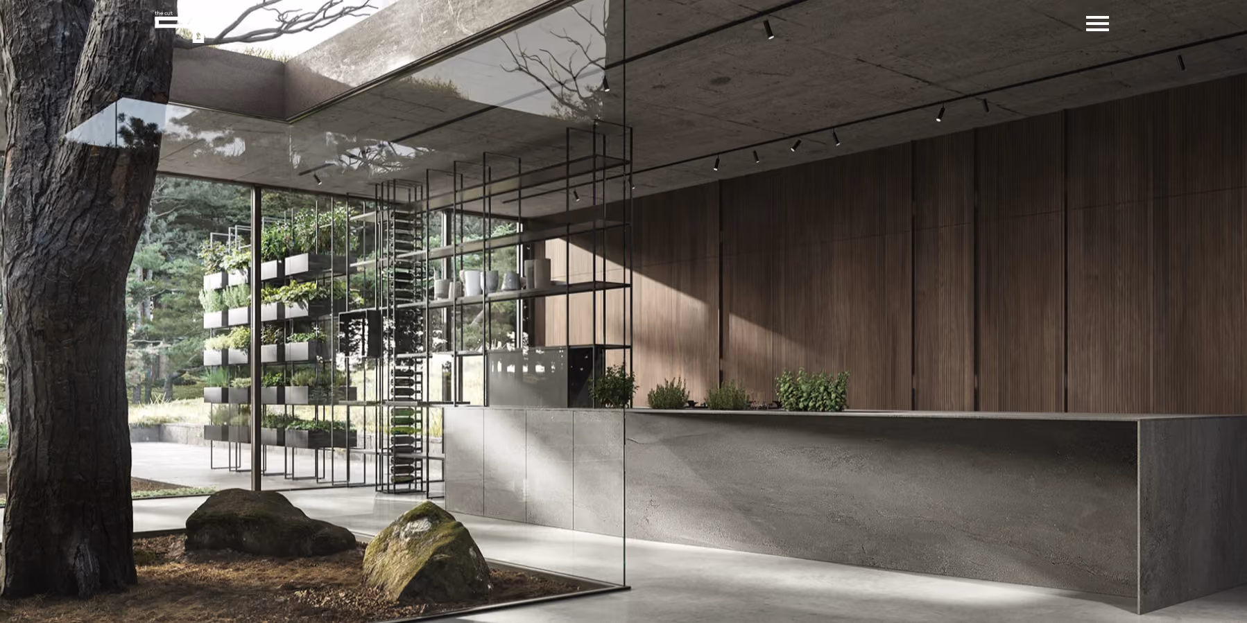 Modern kitchen with large glass walls offering a view of an outdoor area with trees and rocks, featuring a sleek grey stone counter and wooden paneling on one side.