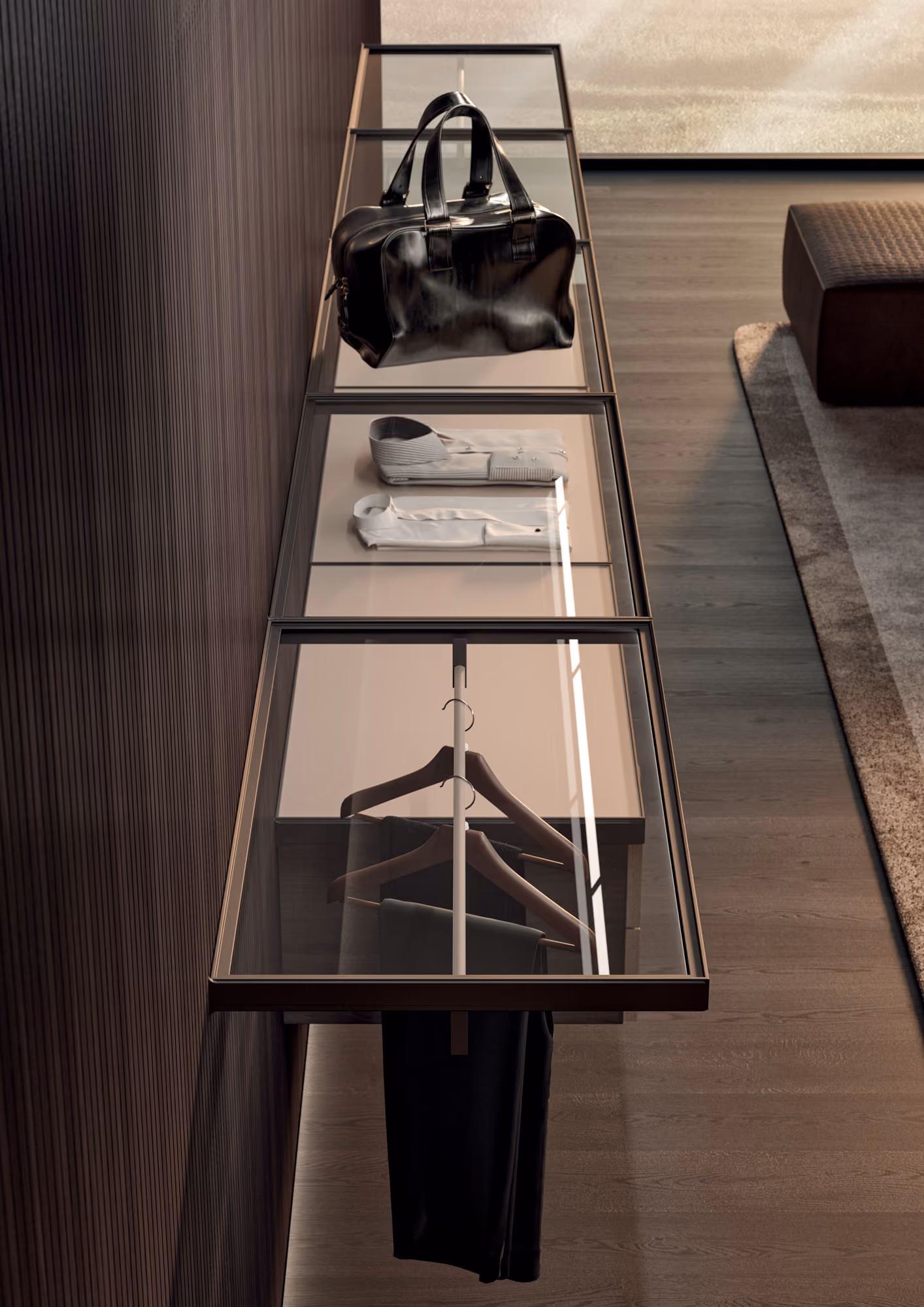 Wall-mounted glass shelves holding a black leather bag, folded white shirts, and clothes on wooden hangers.
