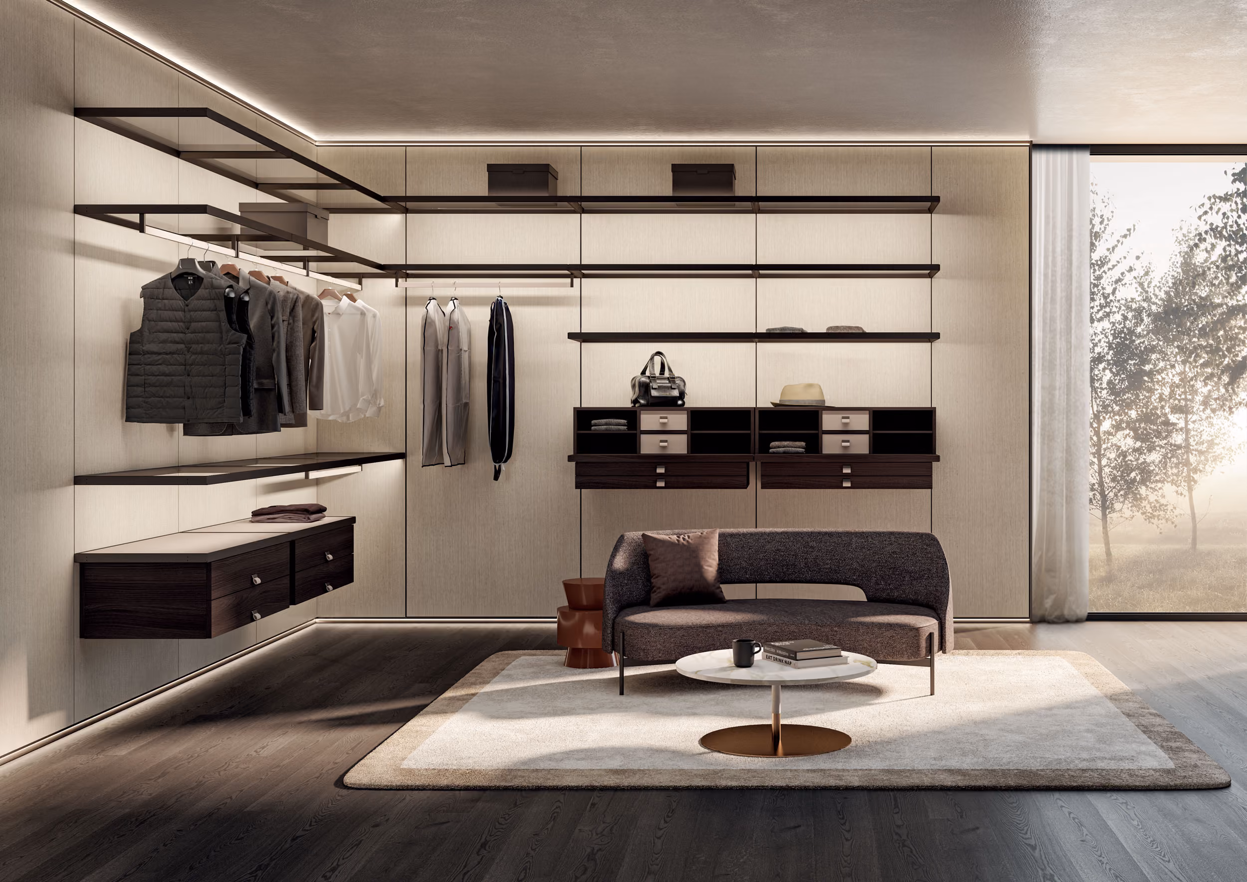 Modern walk-in closet with beige wall panels, open dark wooden shelves and drawers, hanging clothes, a curved gray sofa with pillows, a round white coffee table on a beige rug, and a large window showing trees outside.