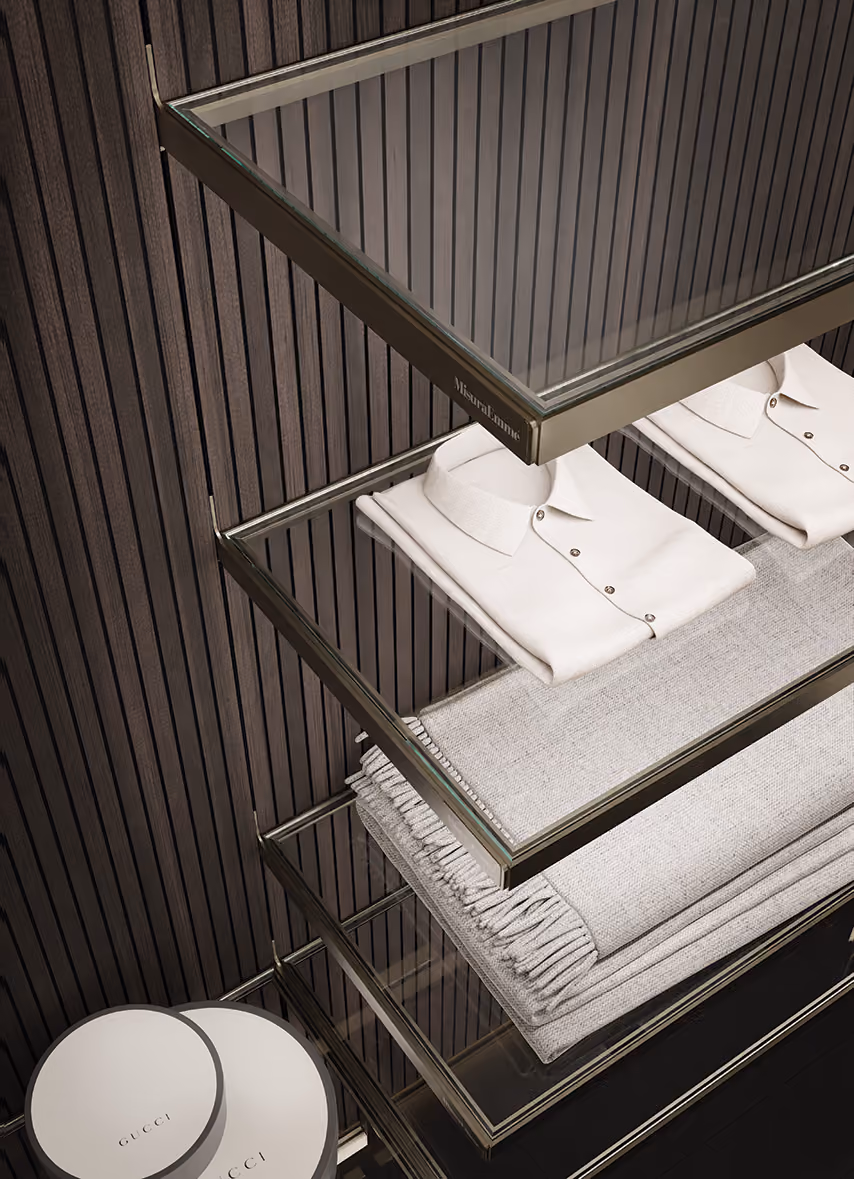 Folded white shirts and gray folded scarves on glass shelves with dark vertical wood panel background.