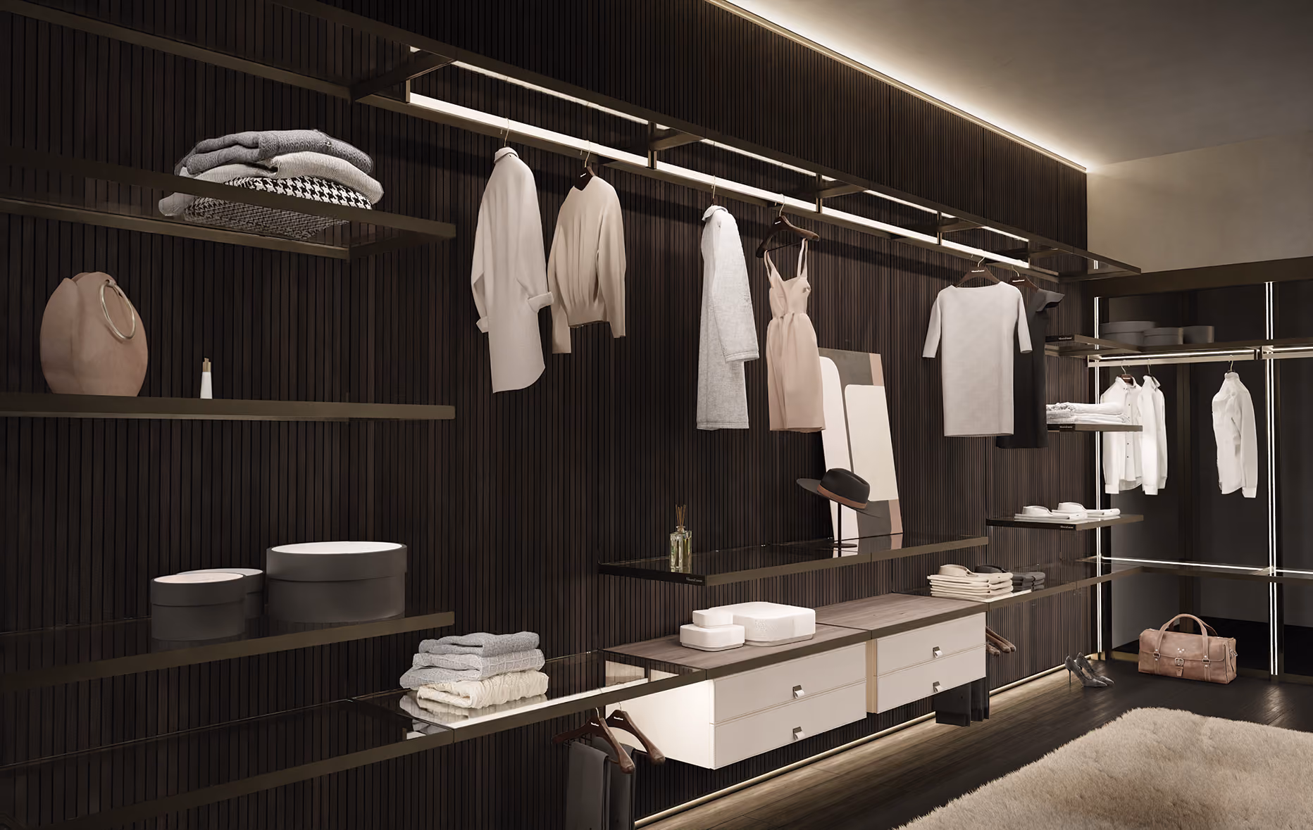 Modern walk-in closet with hanging clothes, folded sweaters, hats, shoes, and bags on dark wood walls.