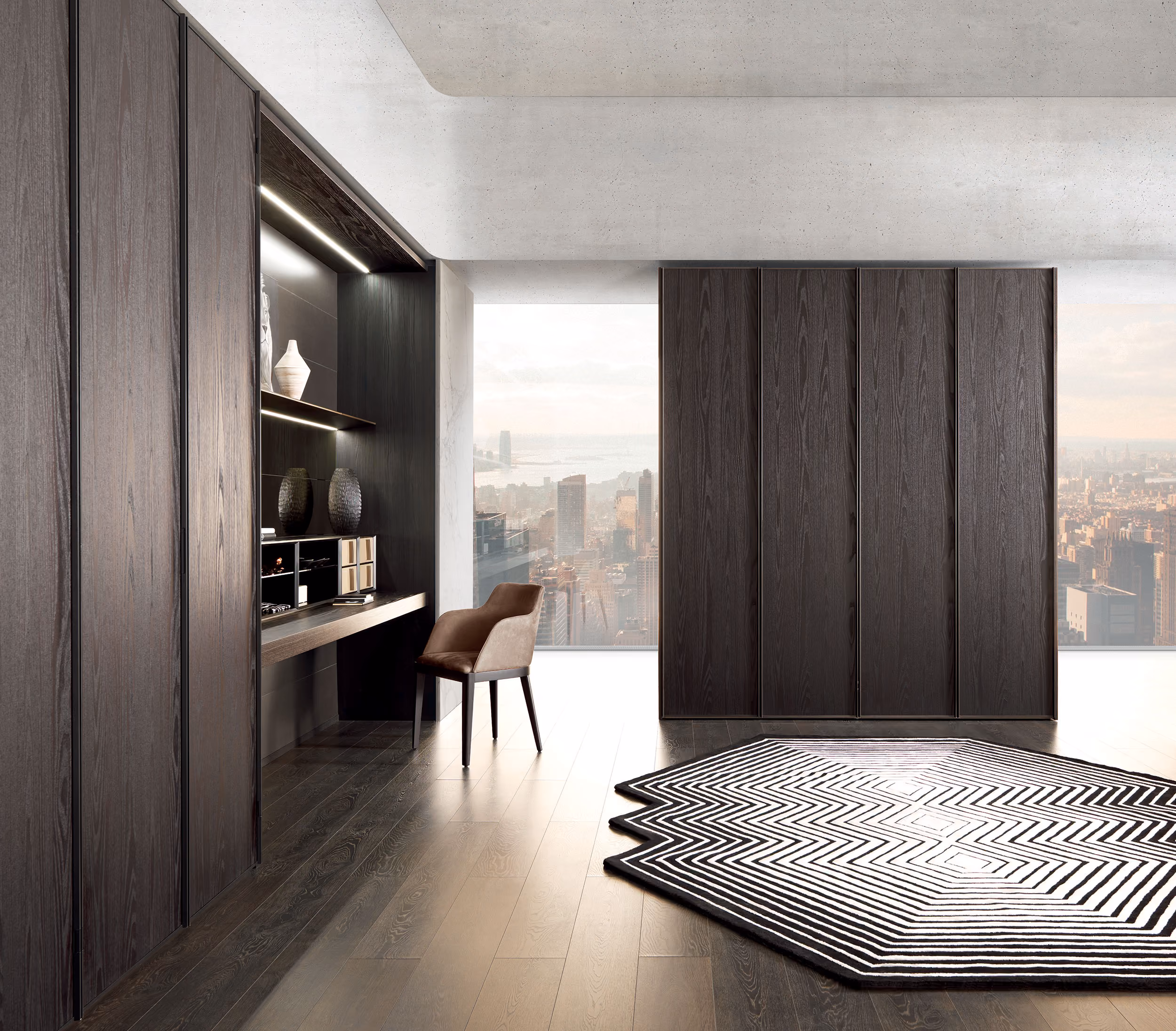 Modern interior with dark wood paneling and flooring, a built-in desk with shelves and decorative vases, a brown chair, large windows overlooking a cityscape, and a black-and-white geometric rug on the floor.