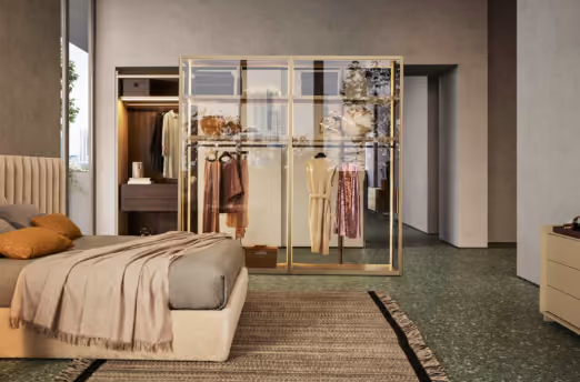 Modern bedroom with a bed covered in beige bedding and pillows, a woven rug on green terrazzo floor, a glass wardrobe displaying hanging clothes, and a wooden dresser.