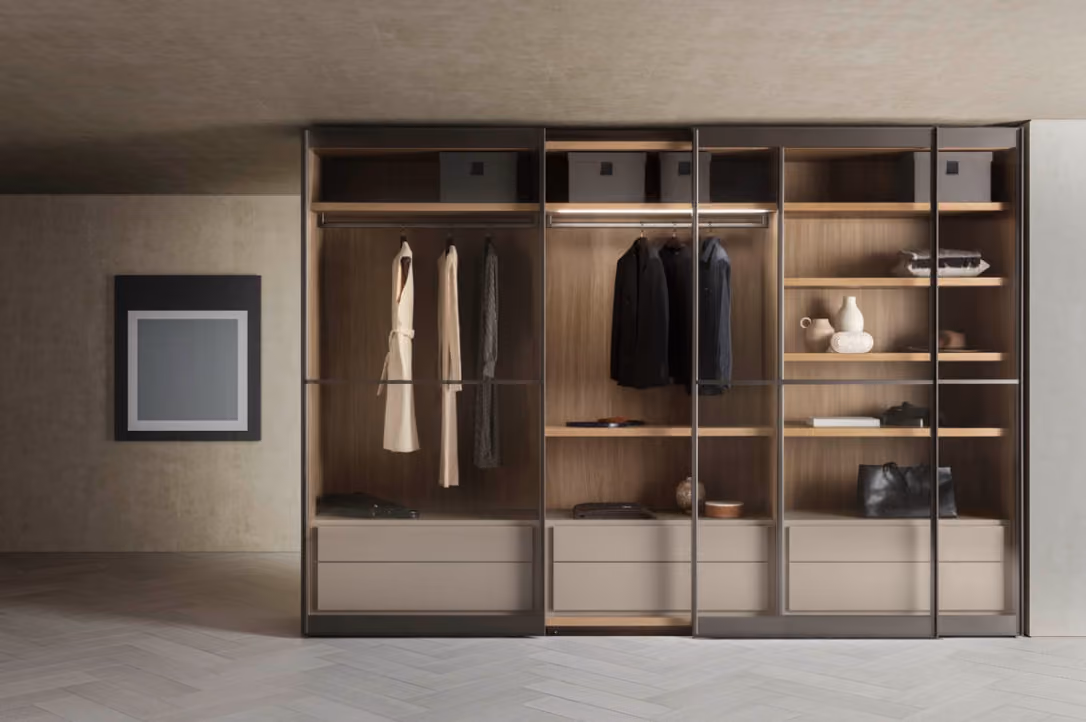 Modern wardrobe with glass doors, wooden shelves, hanging clothes, and accessories inside.