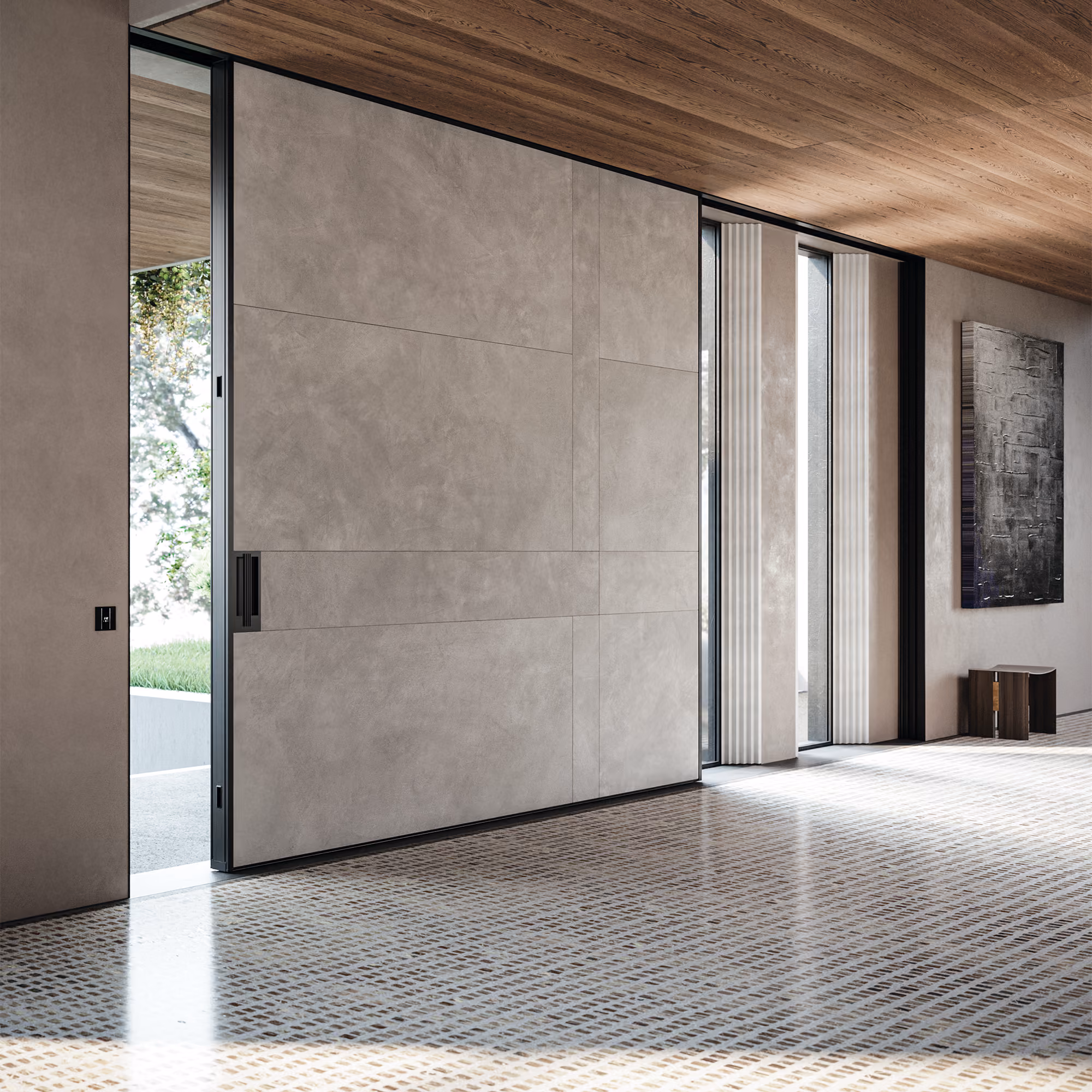 Modern interior hallway with a large closed gray concrete pivot door slightly open to show an outdoor area with greenery, tiled floor with a grid pattern, wooden ceiling, tall vertical windows with white vertical blinds, and a small dark wooden side table under a textured wall art piece.