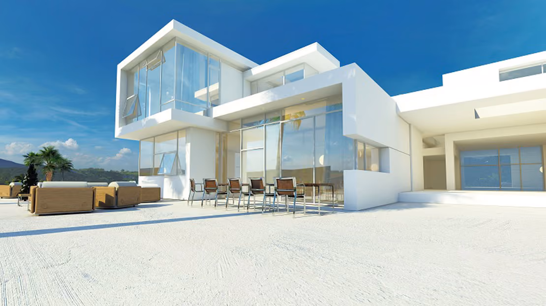 Modern white two-story house with large glass windows and outdoor furniture including a dining table with eight chairs and sofas on a spacious terrace under blue sky.