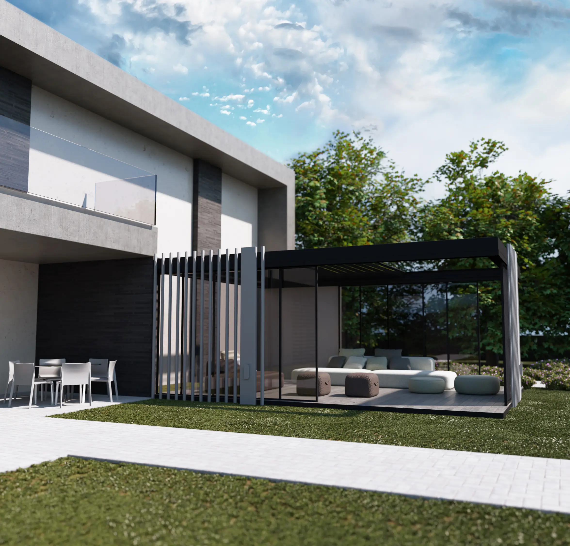 Modern outdoor living area with a sleek black-framed glass gazebo containing a white sectional sofa and round ottomans, adjacent to a contemporary house with a balcony and outdoor dining table with chairs on a paved patio, set on green lawn with trees in the background under a partly cloudy blue sky.