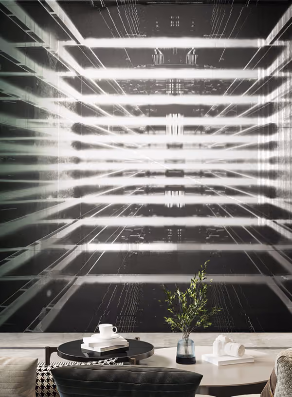 Modern living room with a round black coffee table holding a cup and books, a light-colored side table with a green leafy plant in a glass vase and a white camera, set against a large abstract black and white wall art featuring horizontal bright white light lines and geometric patterns.
