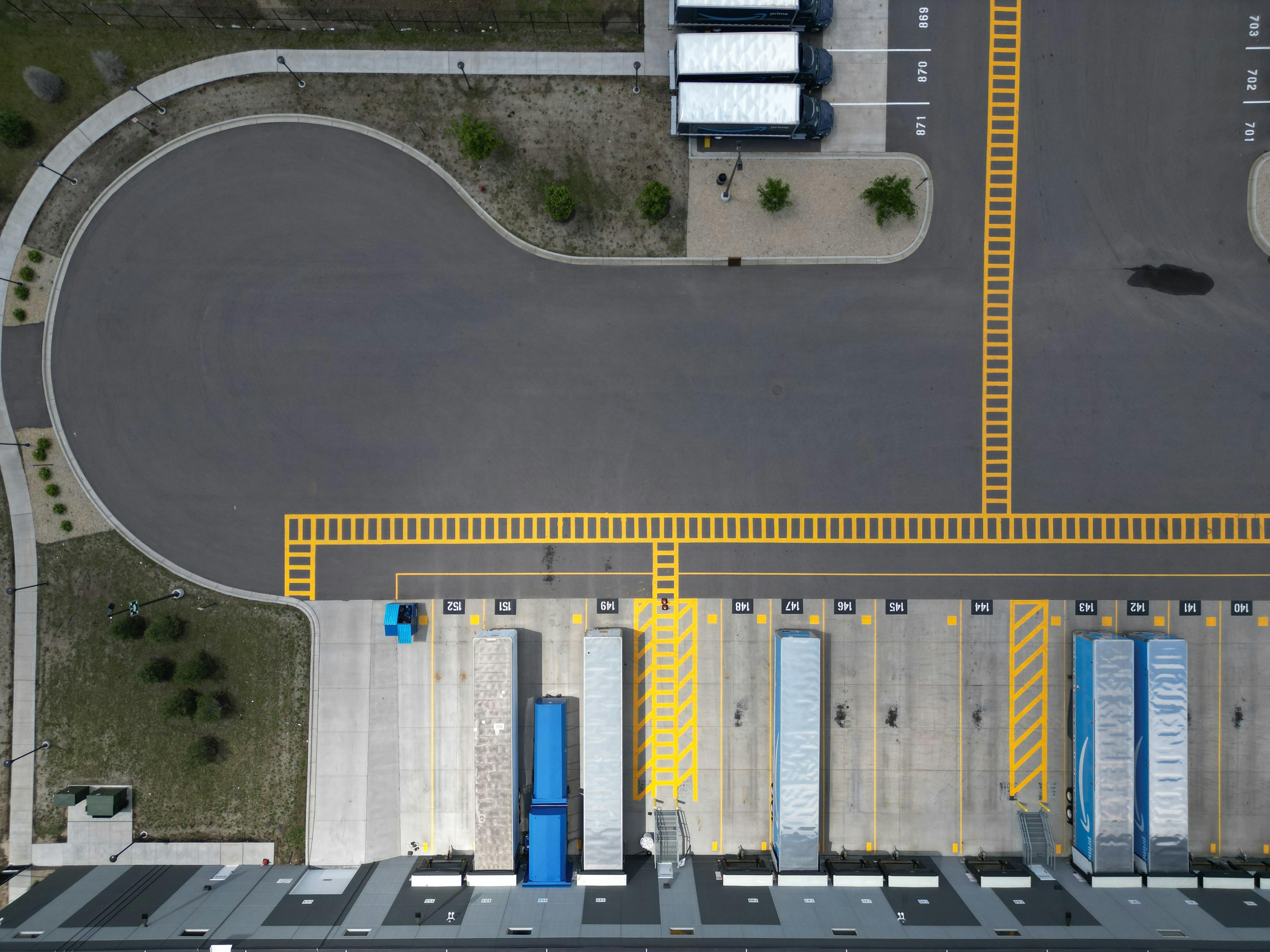 Overhead view of trucks loading and unloading at a fulfillment center