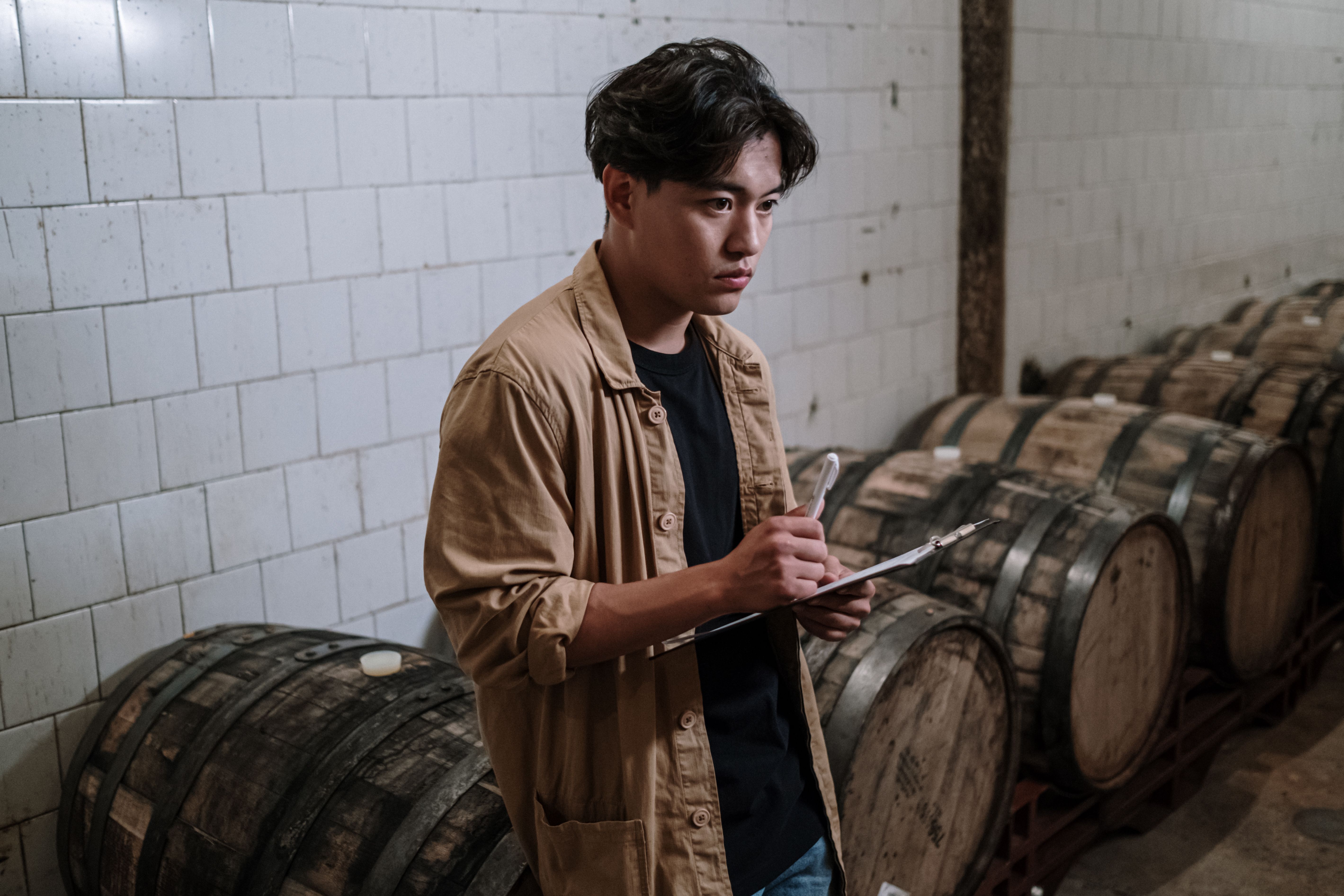 A worker analyzing a printed bill of materials document for inventory management.