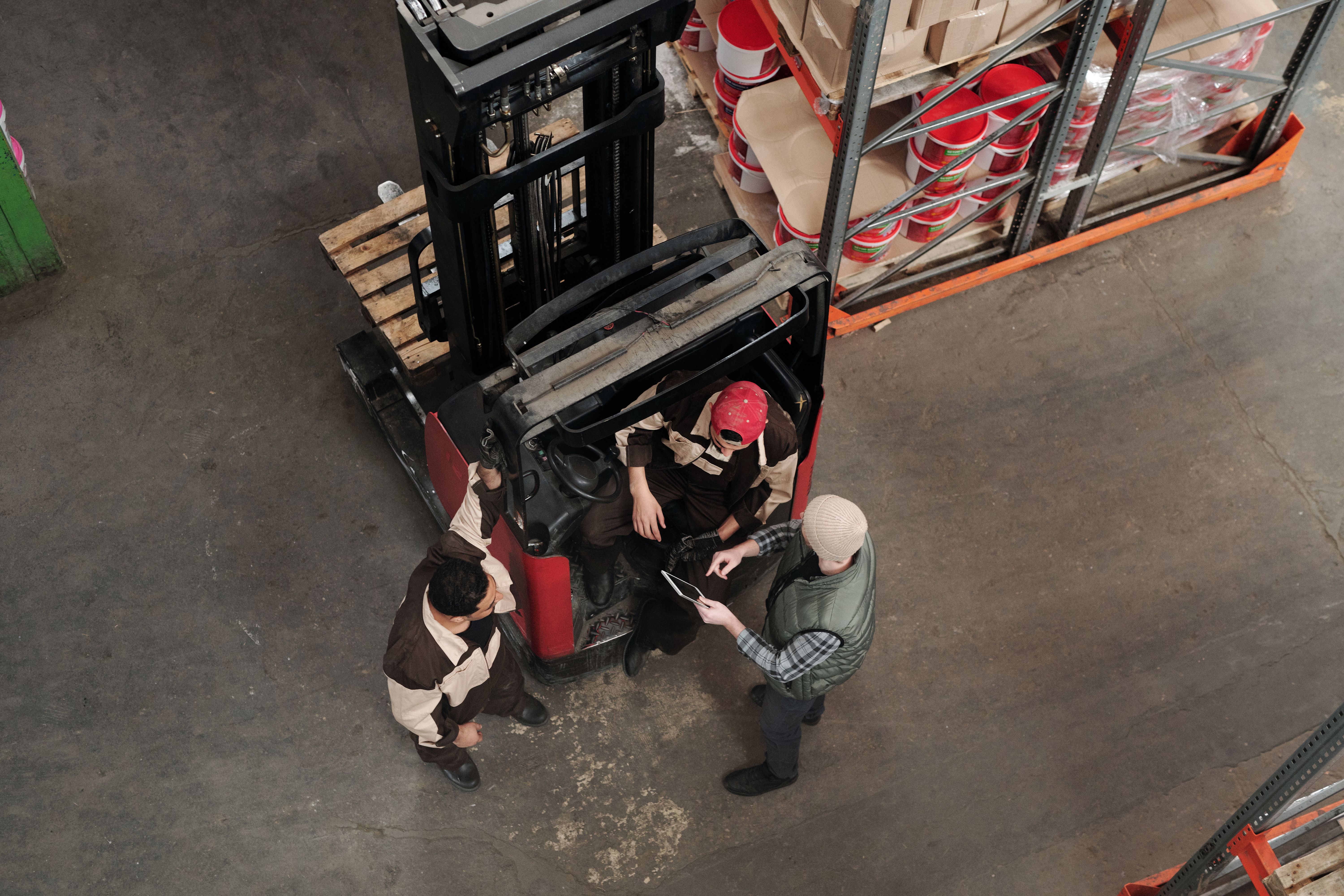 A small team huddle on the plant floor, staff in uniform gathered around a manager holding a checklist.