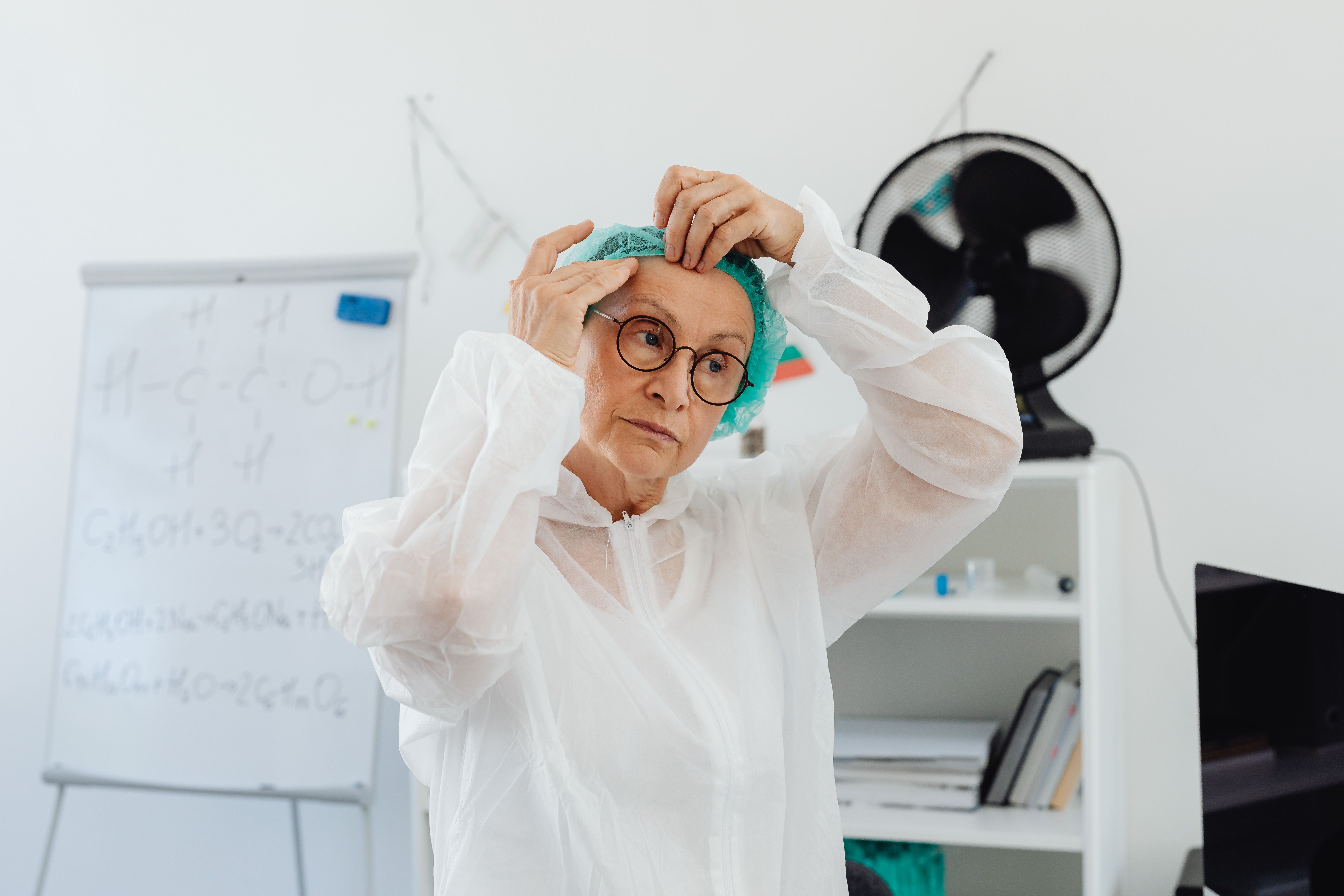 A food safety auditor in a hairnet and lab coat, clipboard in hand, standing on the food production floor.   