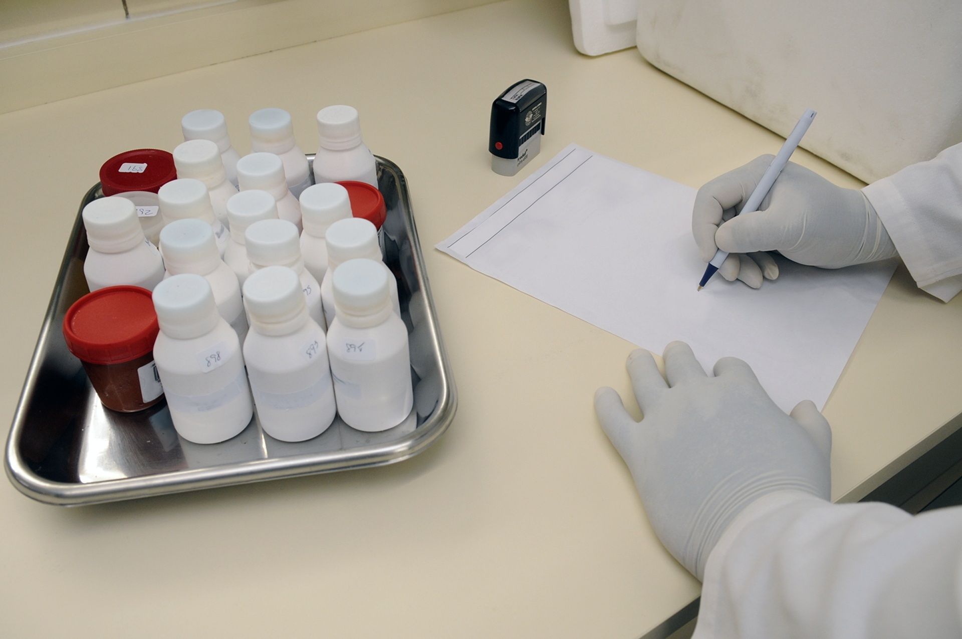  Employee's hands stamping a Certificate of Analysis next to a sealed cannabis product batch.