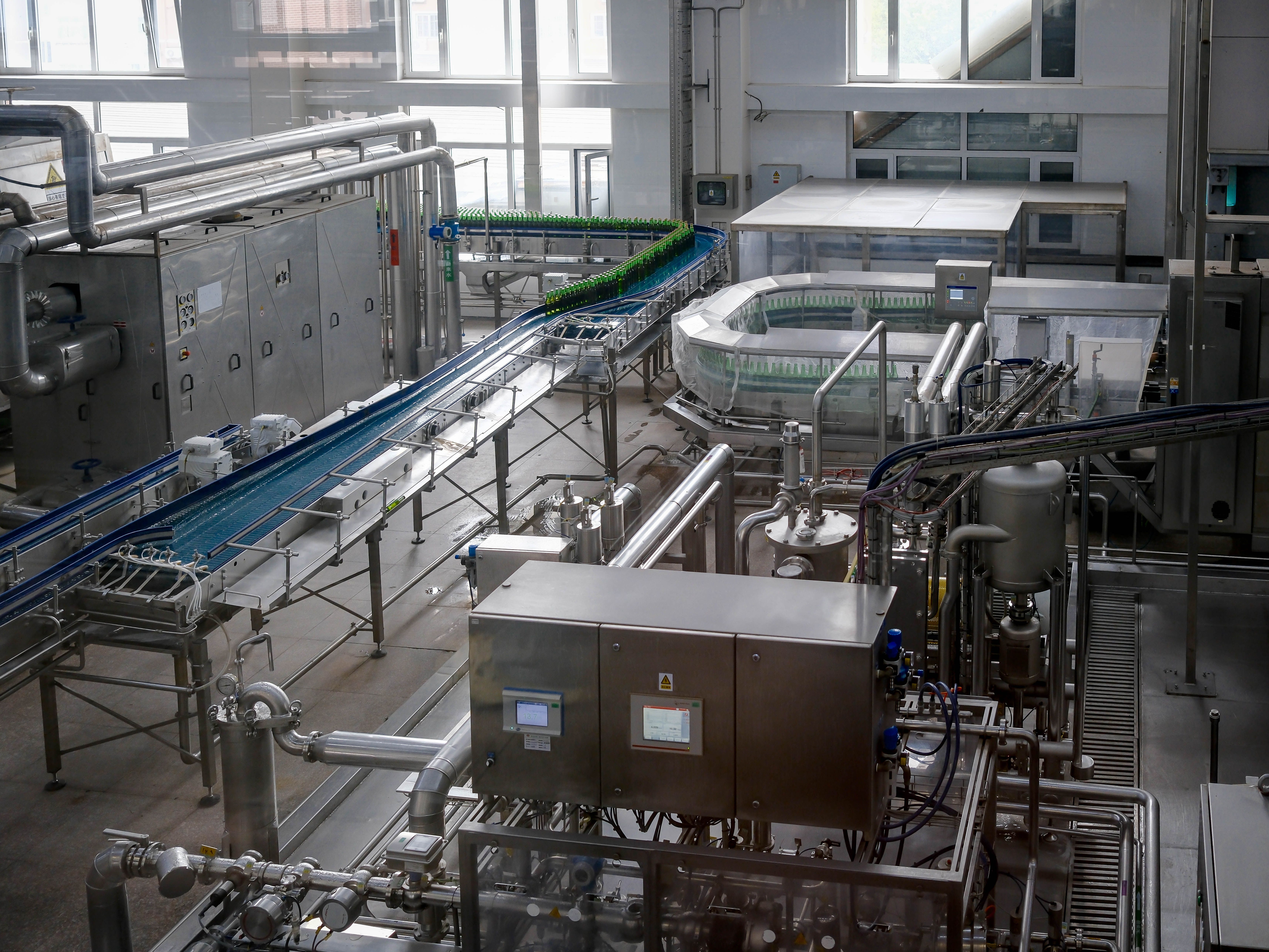 A production line with a product moving along a conveyor and a sensor mounted above the line. 
