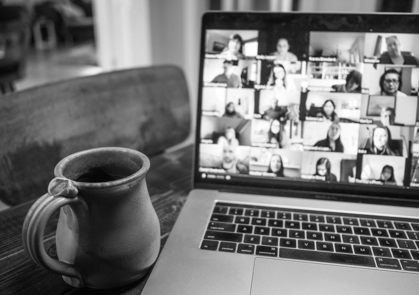 Laptop showing a Zoom webinar grid next to a coffee mug