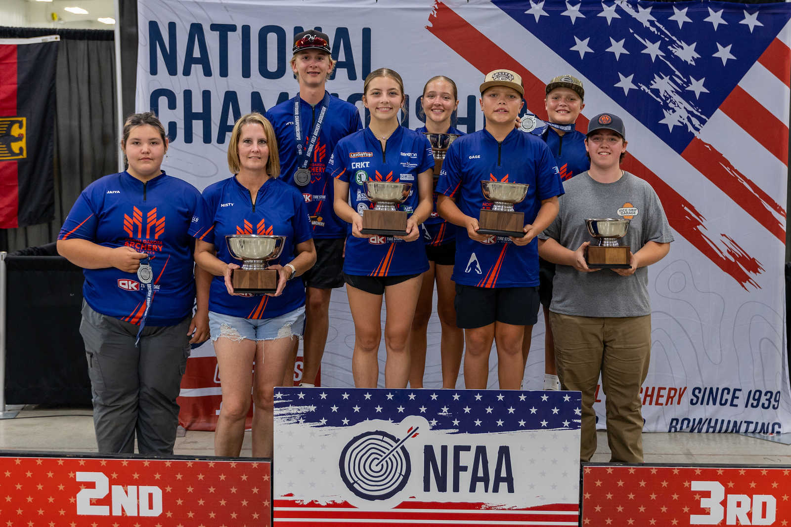 Archers on the podium at an NFAA national championship holding trophies