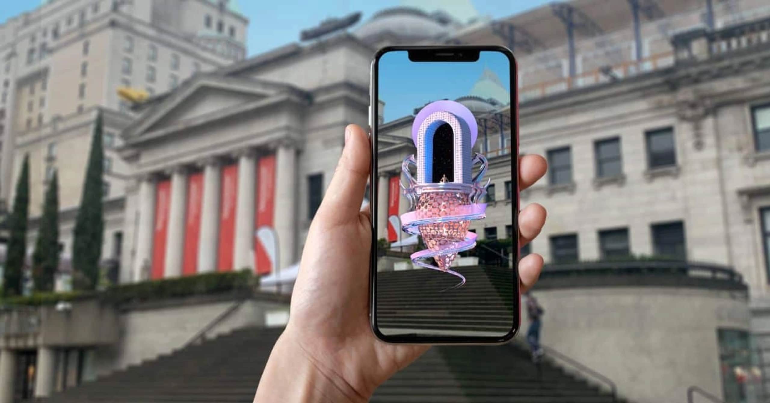 photo hand holding phone with AR art infront of Vancouver Art Gallery