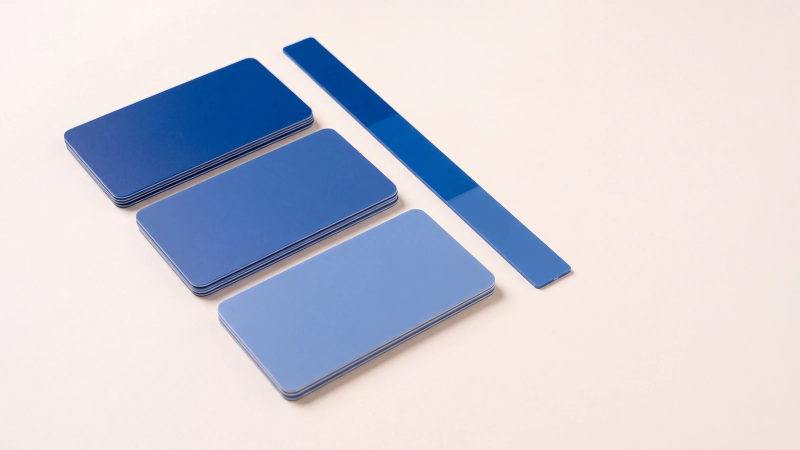 Three stacks of blue plastic cards compared against a colour reference strip