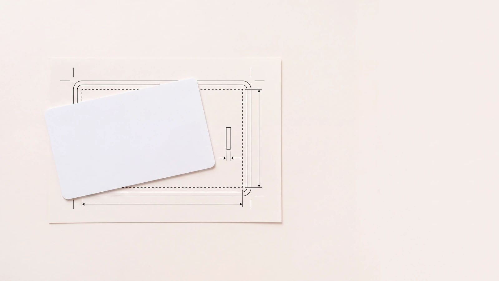 Blank plastic card resting on a printed dieline layout sheet