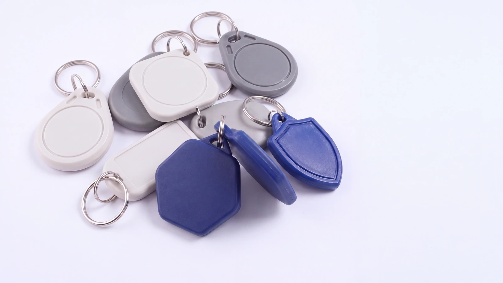 Eight ABS RFID key fobs in different shapes and colours, each with a split ring