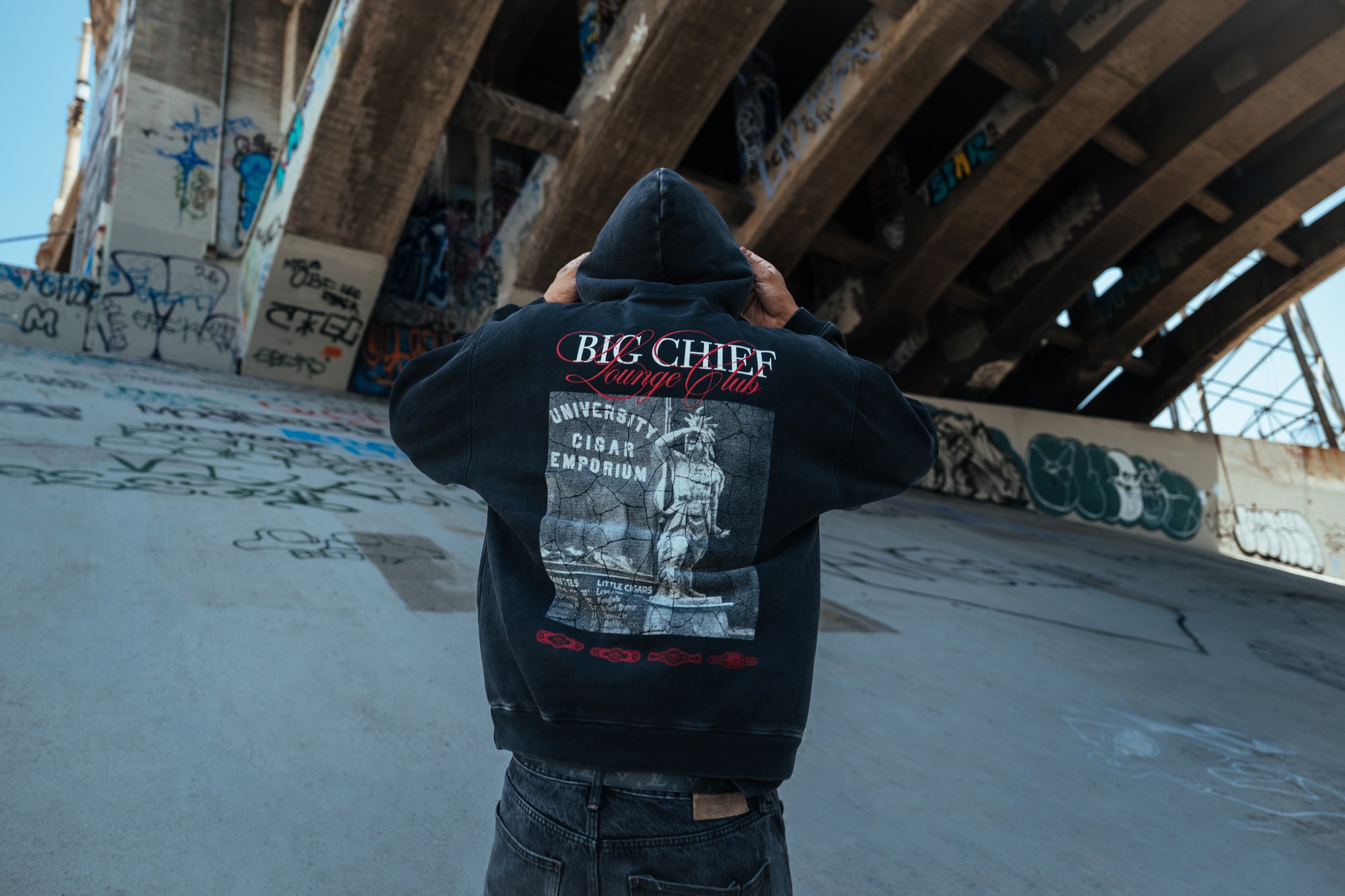 Big Chief Lounge Club hoodie worn under a graffiti-covered Los Angeles bridge