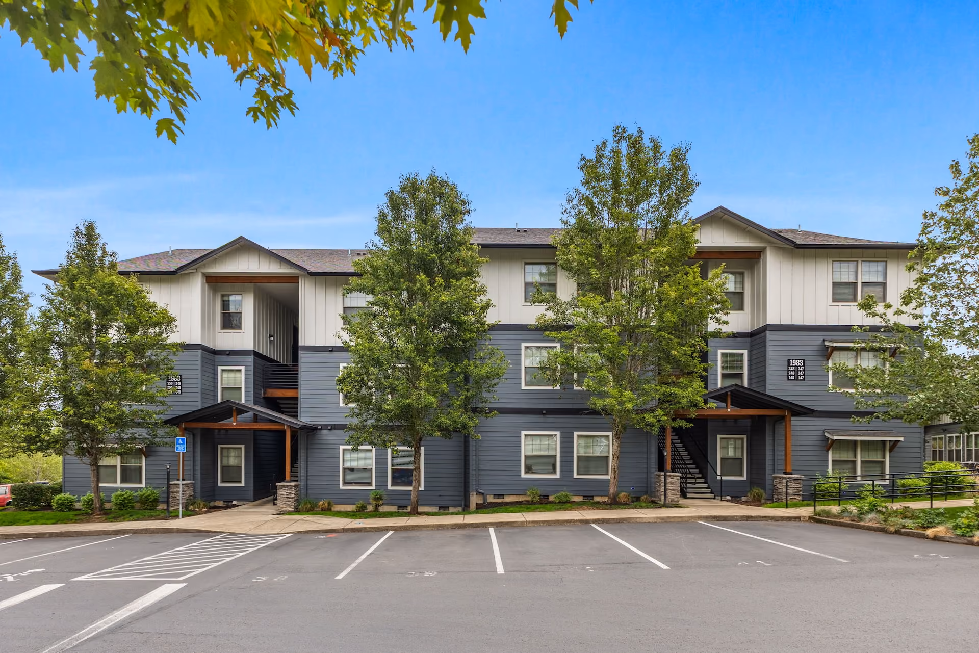 Apartment complex located at the corner of a street, featuring multiple floors and a landscaped entrance of Orchard Ridge in Salem, Oregon