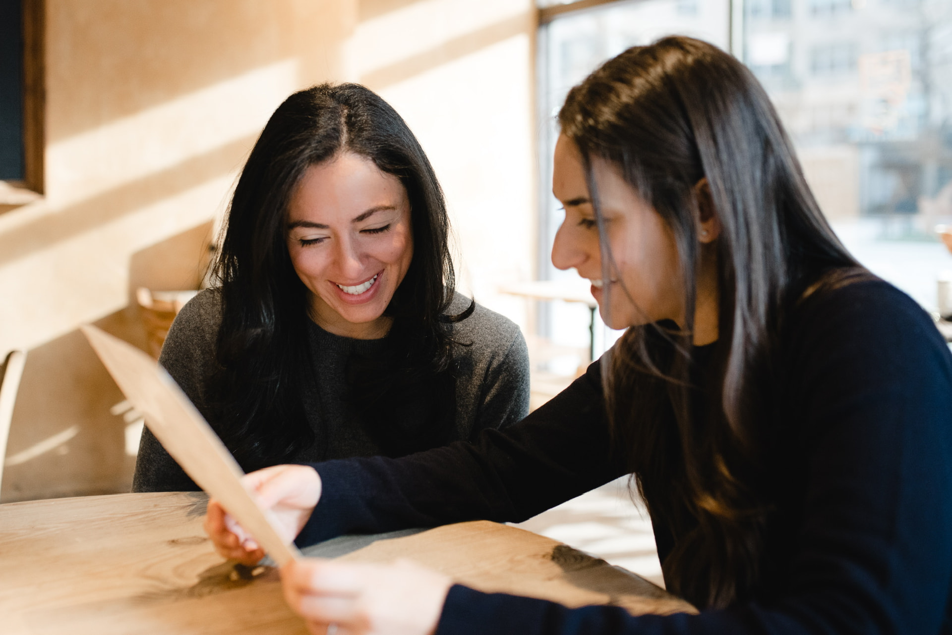 Two founders reviewing a document together across a table in daylight