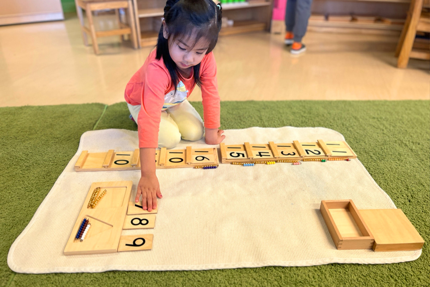 Student working with Montessori tens activity in a Battery Park Montessori classroom