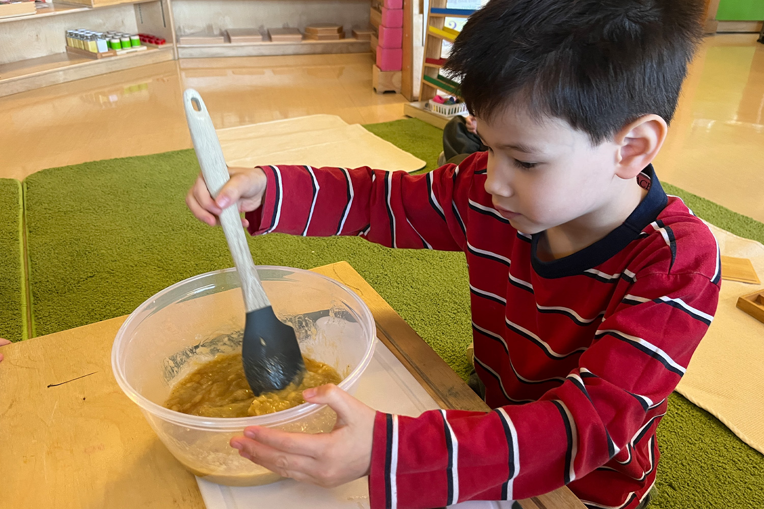 Student mixing banana bread batter in the classroom