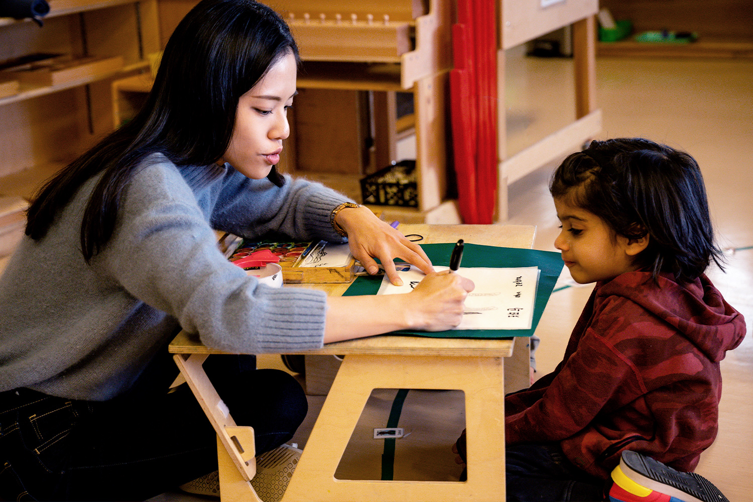 Teacher working with student on Mandarin characters