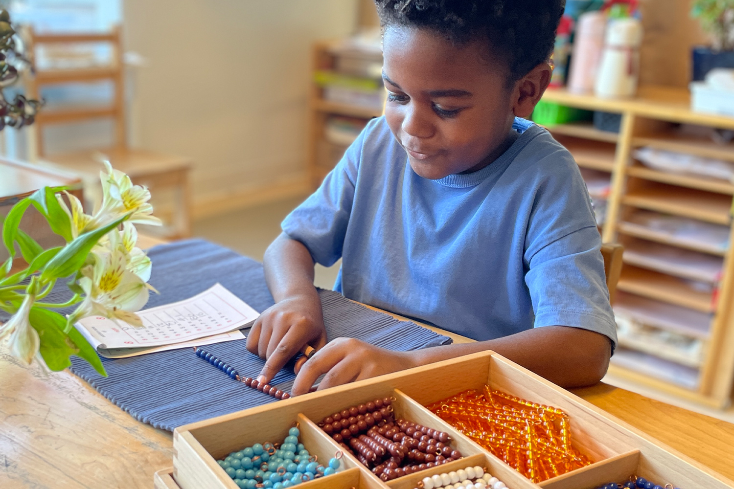 Student working with Montessori beads in a classroom