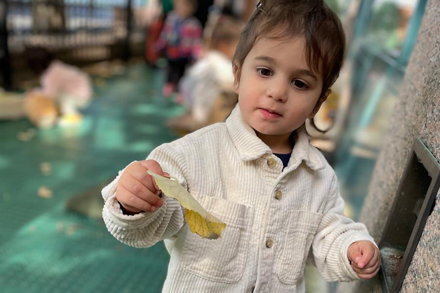 Student showing off a leaf he found during outdoor time in our patio