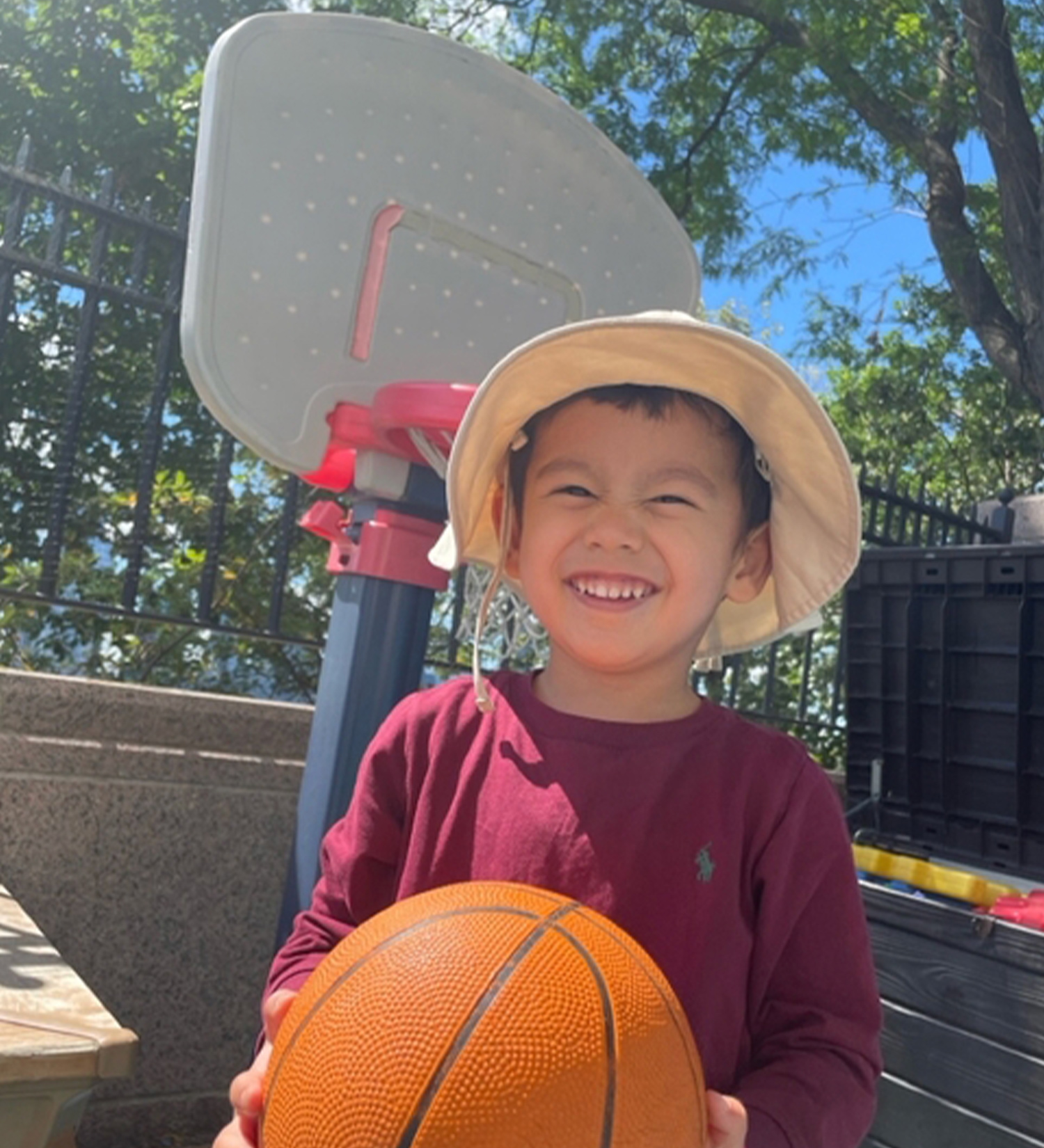 A student/camper playing with a basketball on Battery Park Montessori's private outdoor patio
