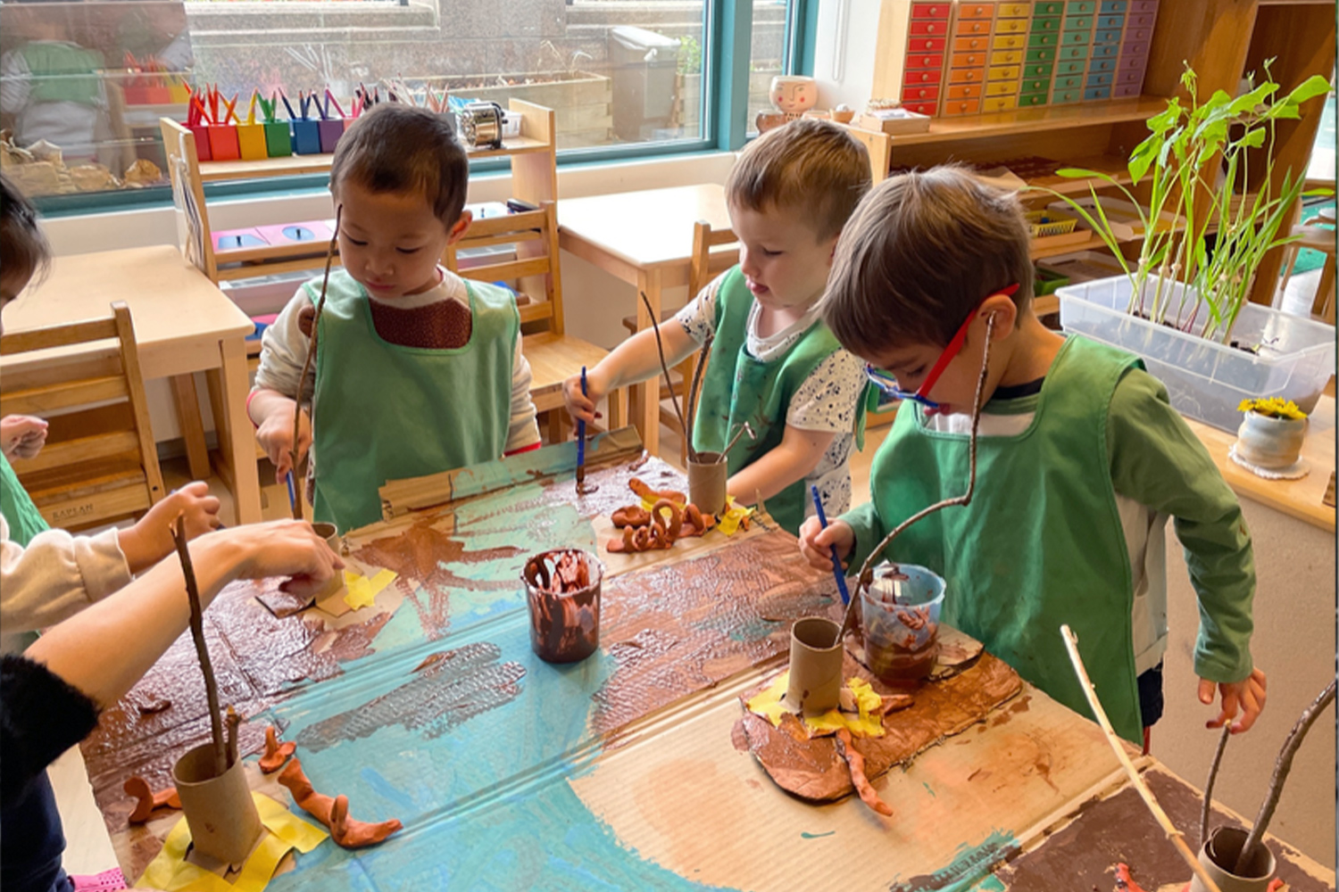 A group of students focused on their art project in the classroom at Battery Park Montessori