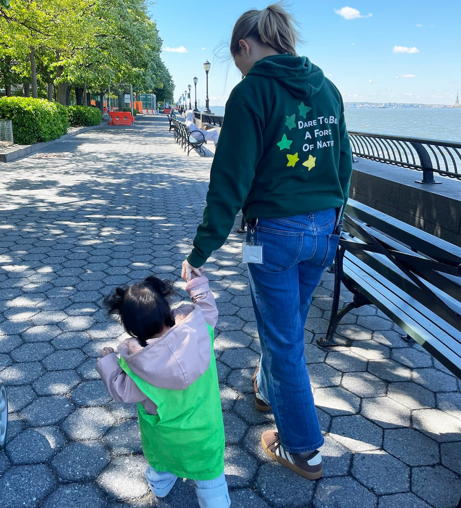 Teacher and student walking along the pathway of Battery Park City's waterfront next to the school