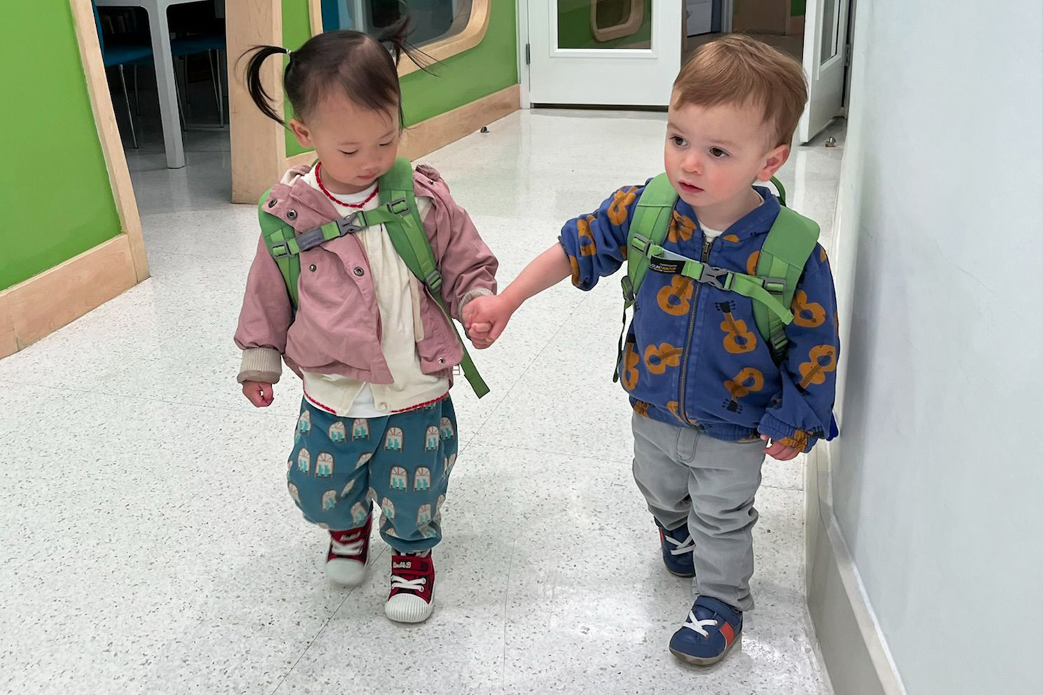 Ready to head out! These two one-year-olds have proudly learned to put on their own jackets, building independence, confidence, and coordination along the way. Now they’re all set for dismissal!