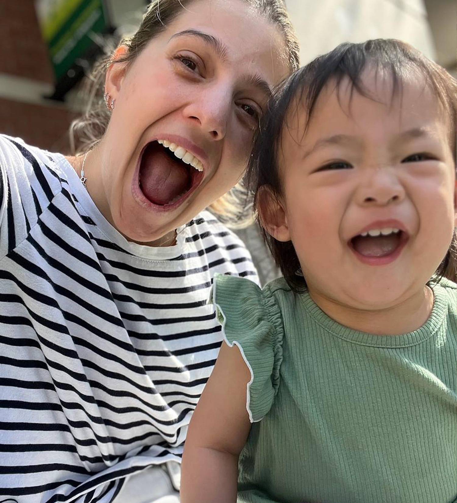 Student smiling with a teacher on the outdoor patio