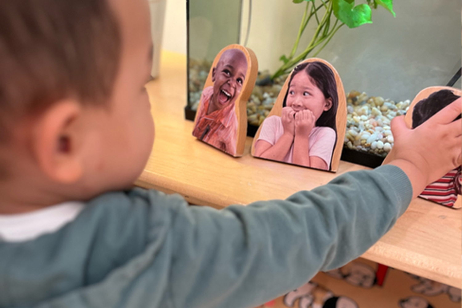 A student reaches for wooden blocks which show children expressing different emotions