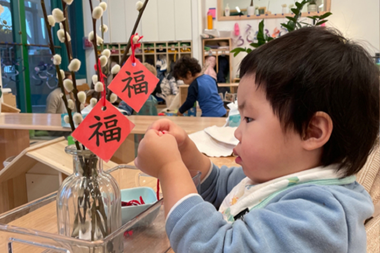 Student hangs decorations for Chinese New Year celebration