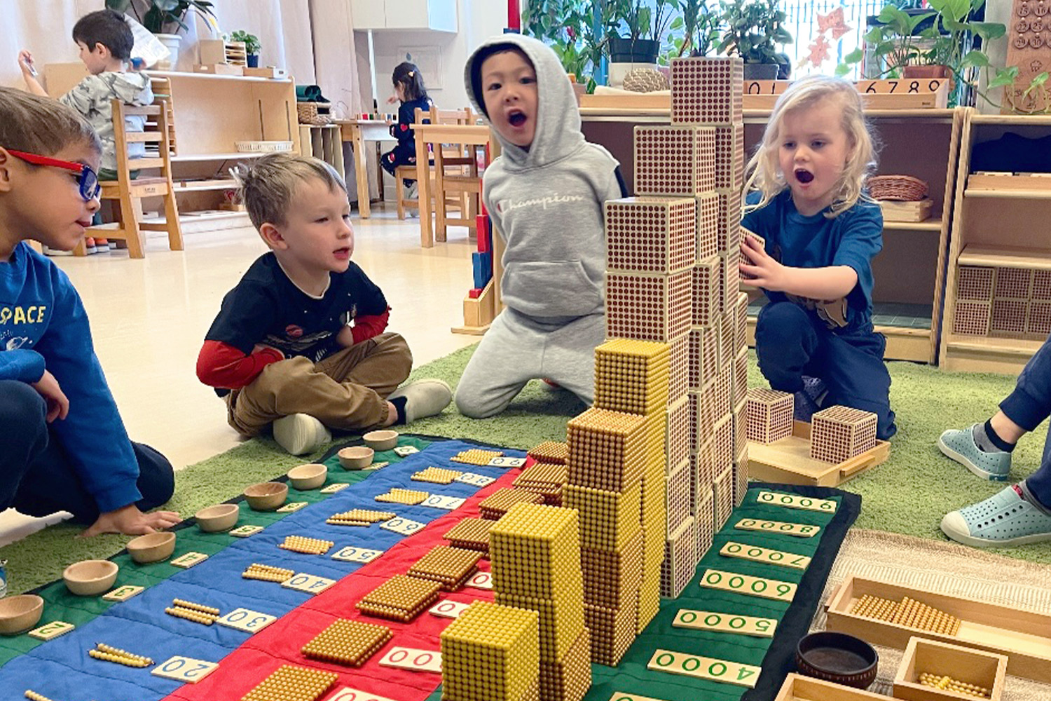 Battery Park Montessori students working together with Montessori hundreds and thousand counting blocks in a moment of joy and wonder